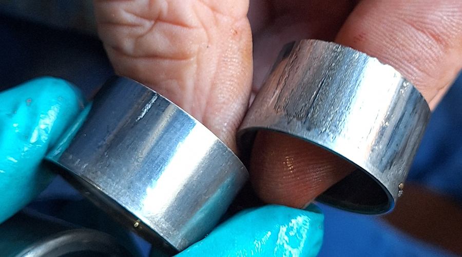 Defekte Nadellager aus einer Hydraulikpumpe, mit Grübchen und dunklen Spuren auf dem Außenring